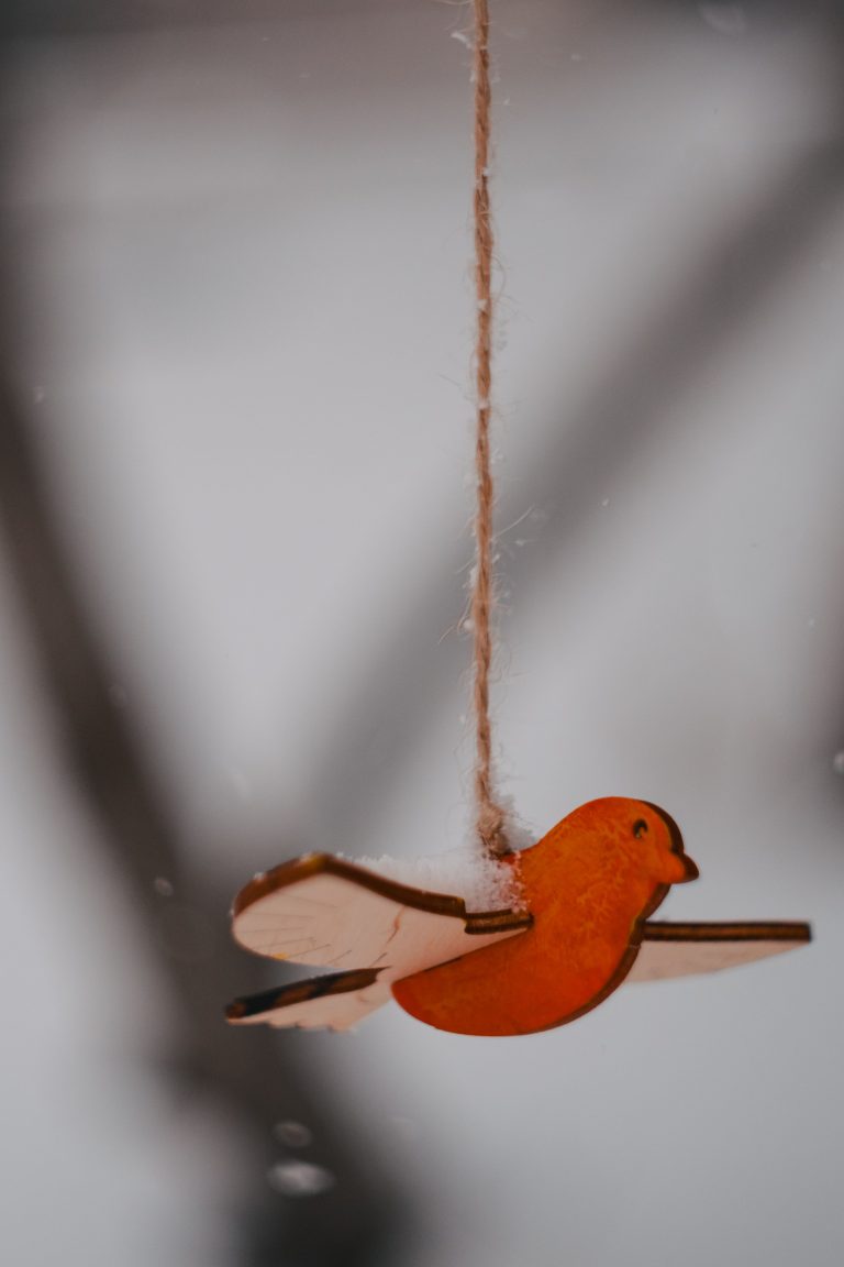 A simple wooden bird ornament captured in soft light, ideal for a vintage decoration theme. Un simple ornement d'oiseau en bois capturé en lumière douce, idéal pour un thème de décoration vintage.