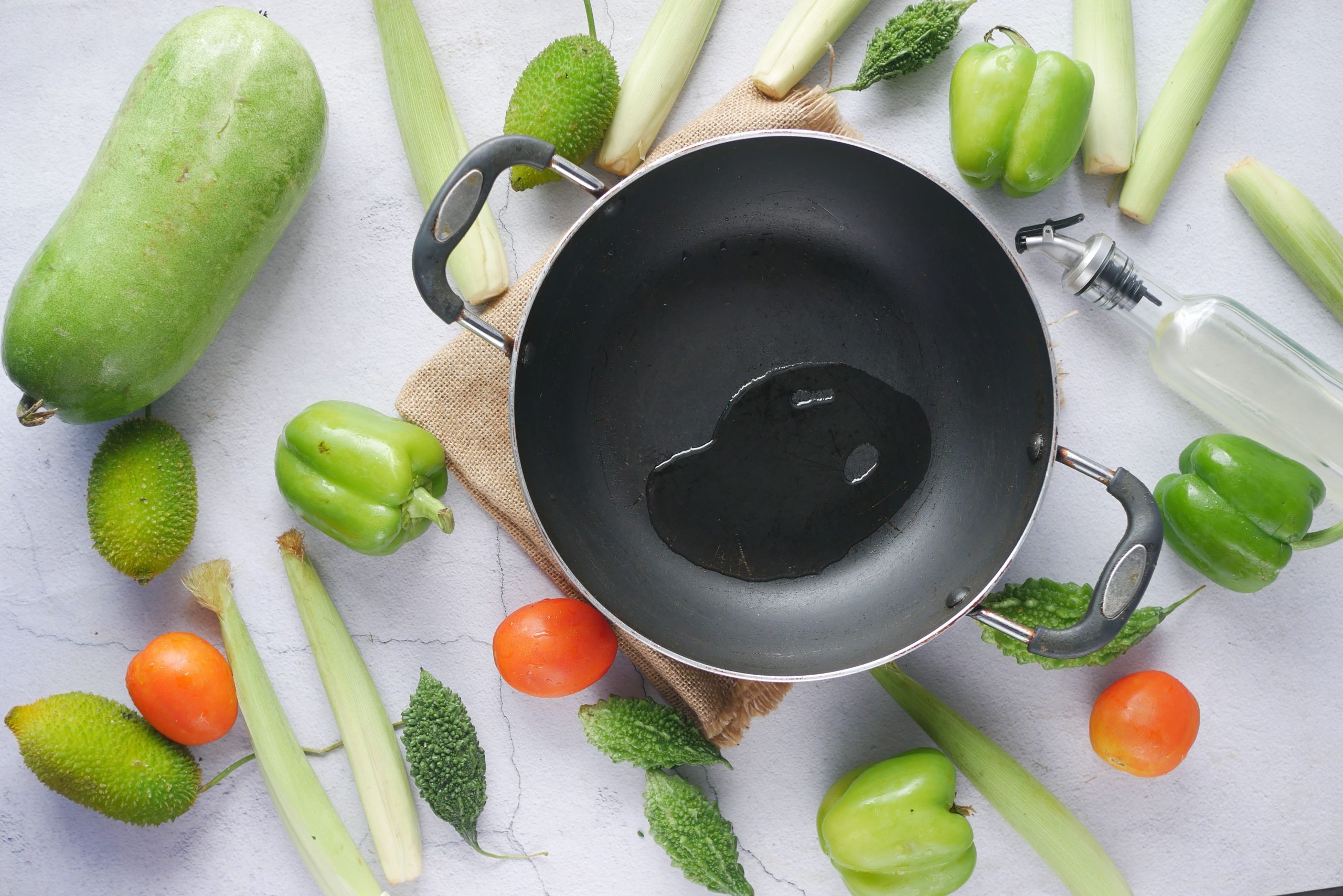 Wok avec légumes frais et huile cuisine
