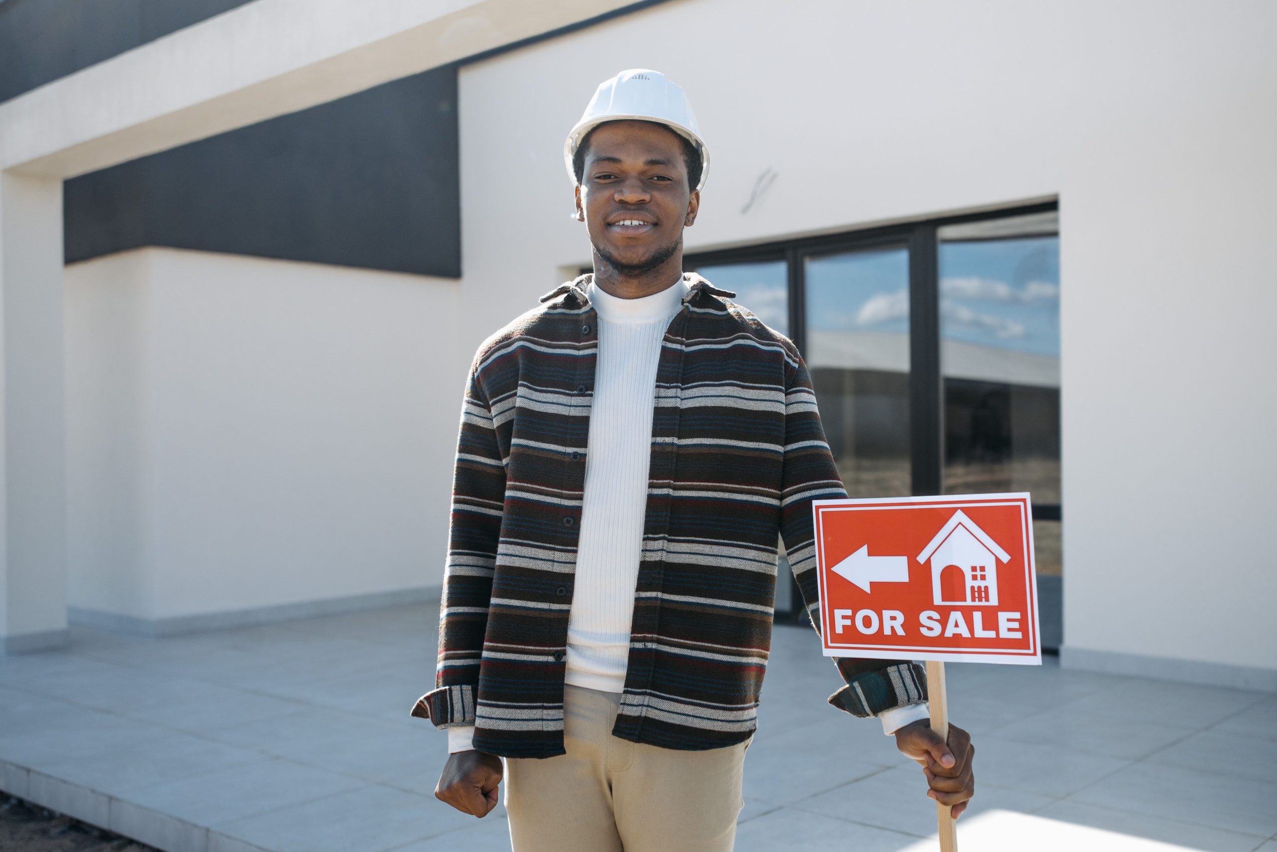 Agent immobilier devant maison à vendre.