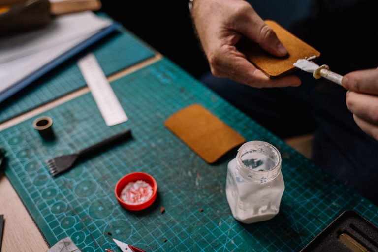 Personne appliquant colle sur cuir artisanal