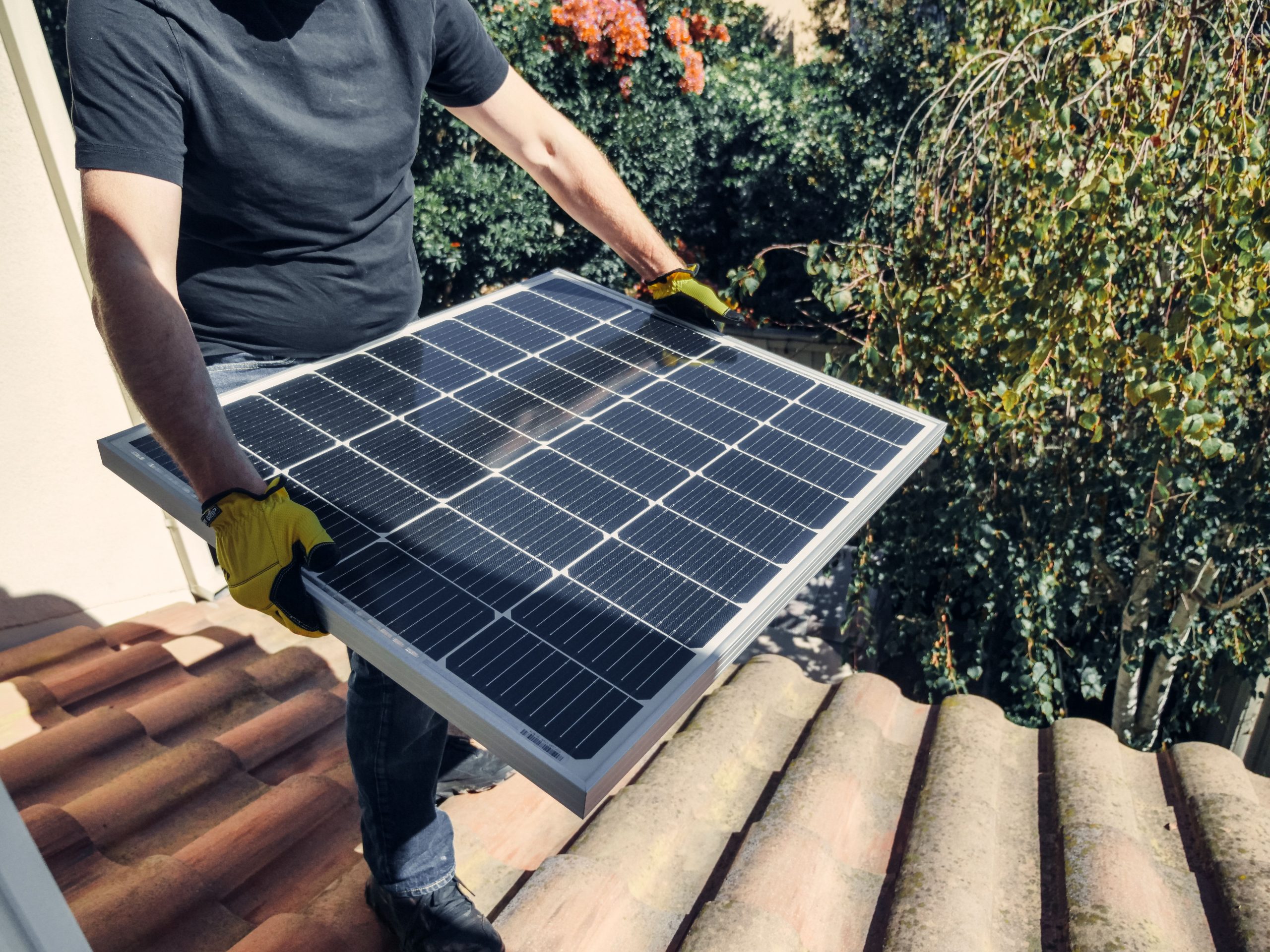 Technicien installe panneau solaire toit