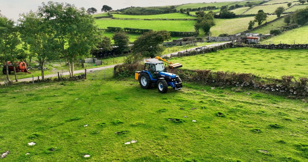 Tracteur bleu travaillant dans champ verdoyant