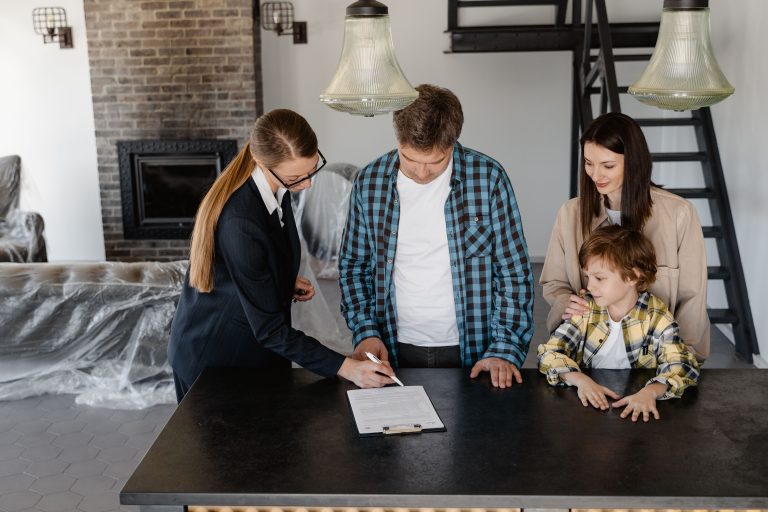 Famille heureuse signant contrat immobilier avec agent