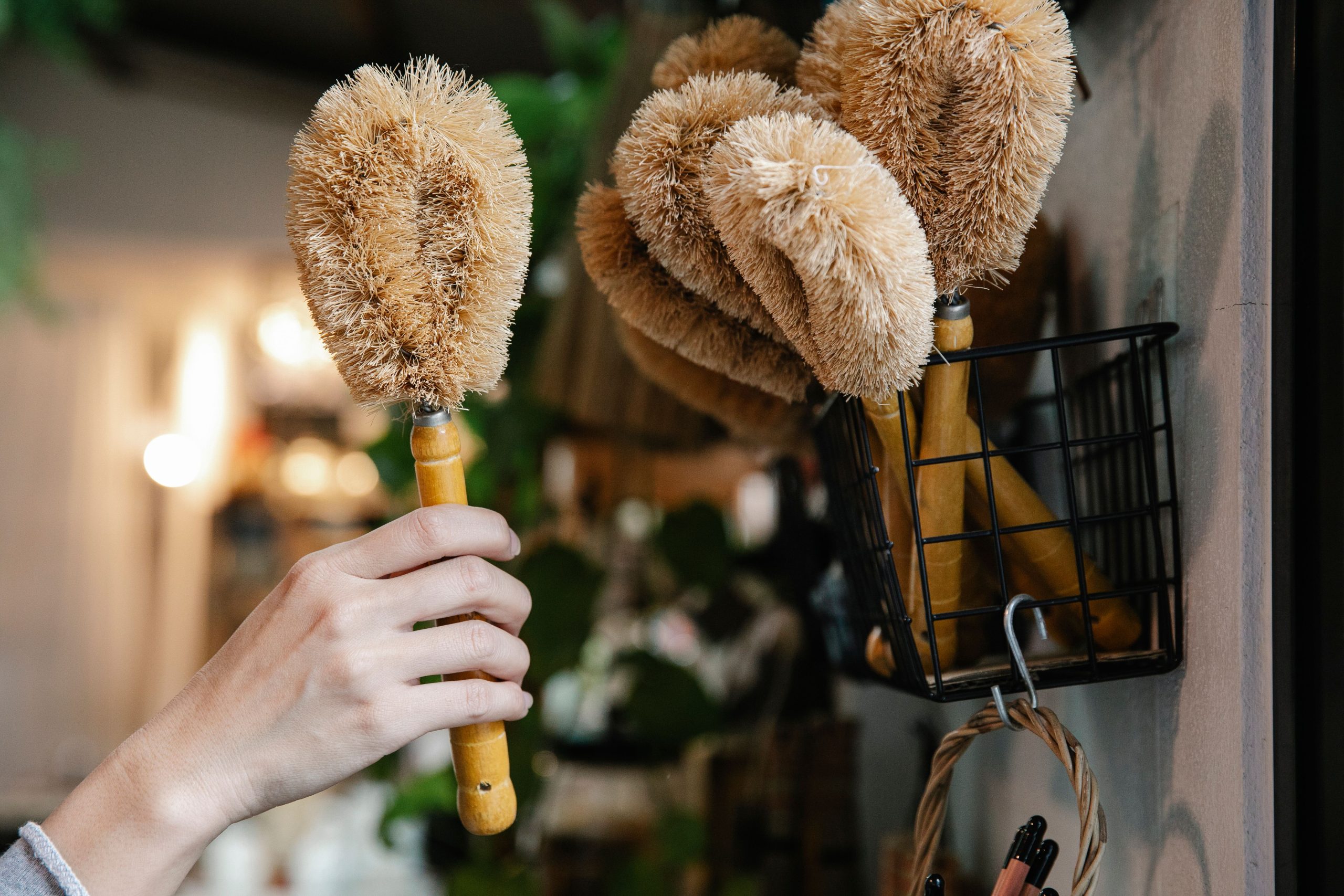 Main sélectionnant des brosses écologiques dans un panier.