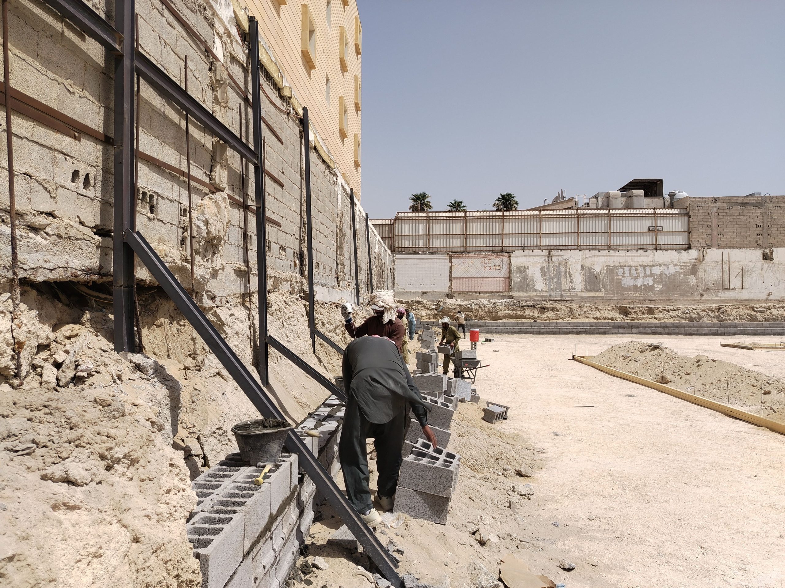 Ouvriers construisant mur parpaing sur chantier
