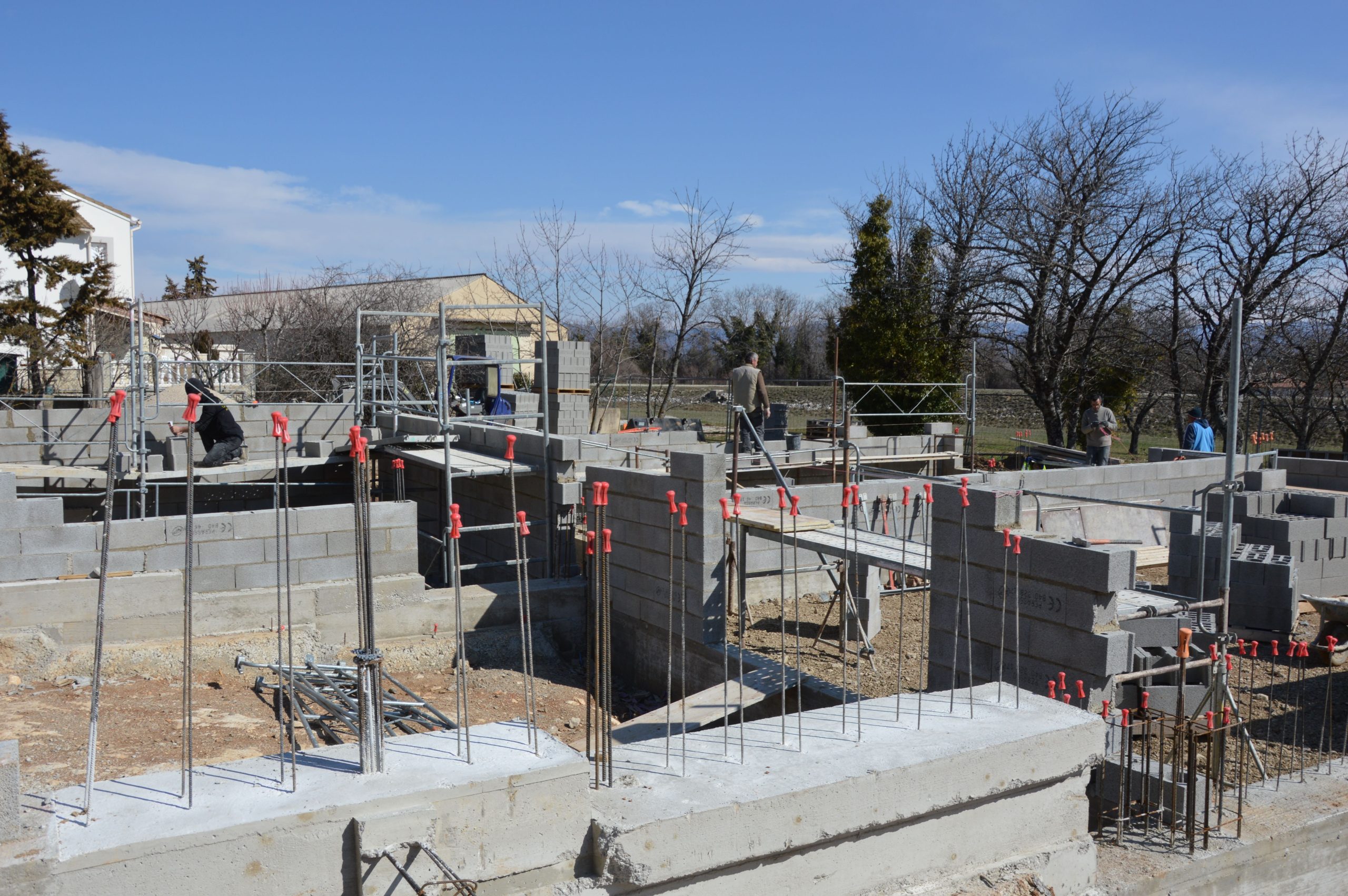 Chantier fondation beton avec ouvriers ciel bleu
