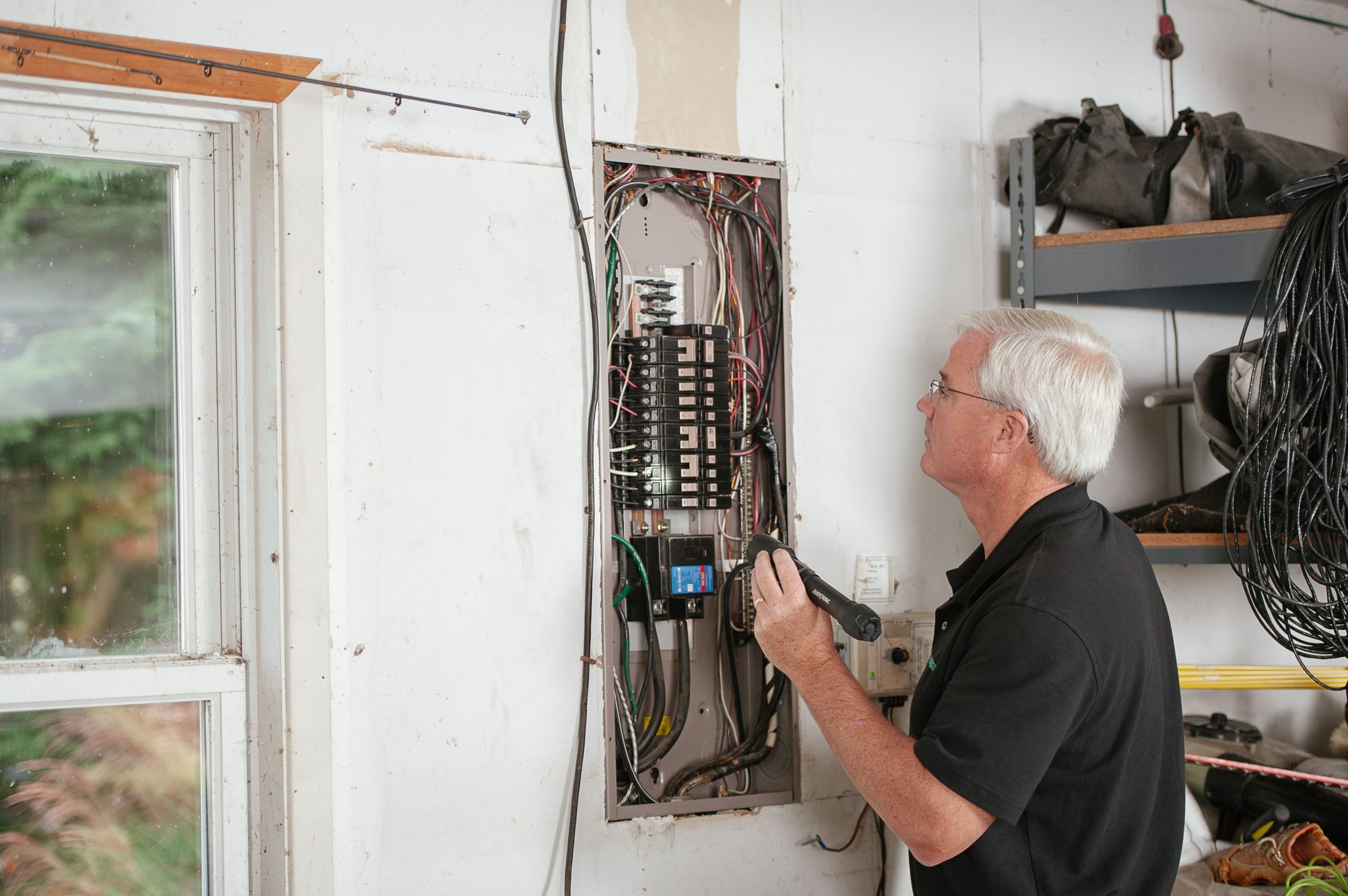 Électricien examinant un boîtier à fusibles résidentiel