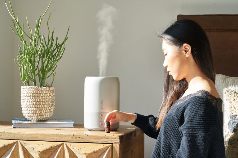 Femme utilisant diffuseur huiles essentielles maison