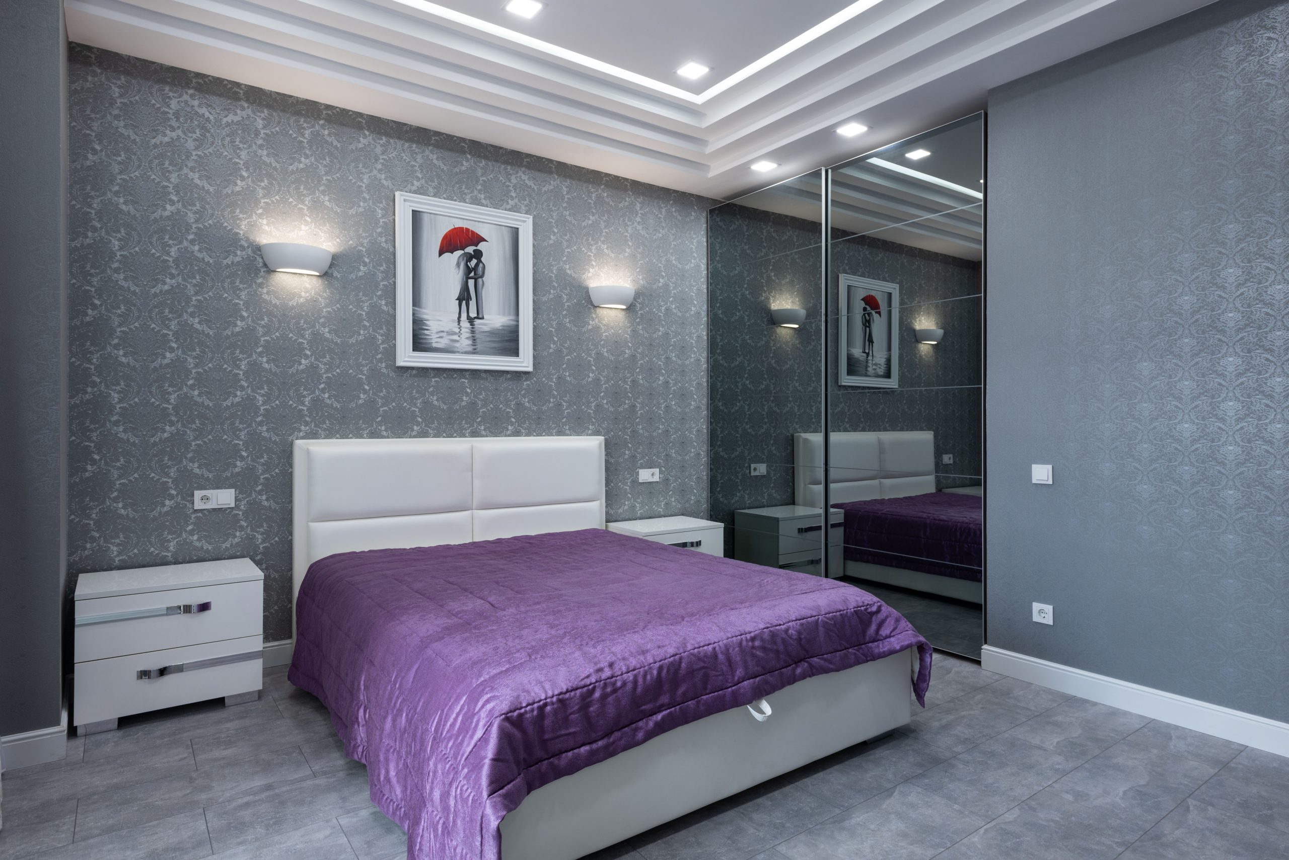 Lit violet près d'un mur gris moderne