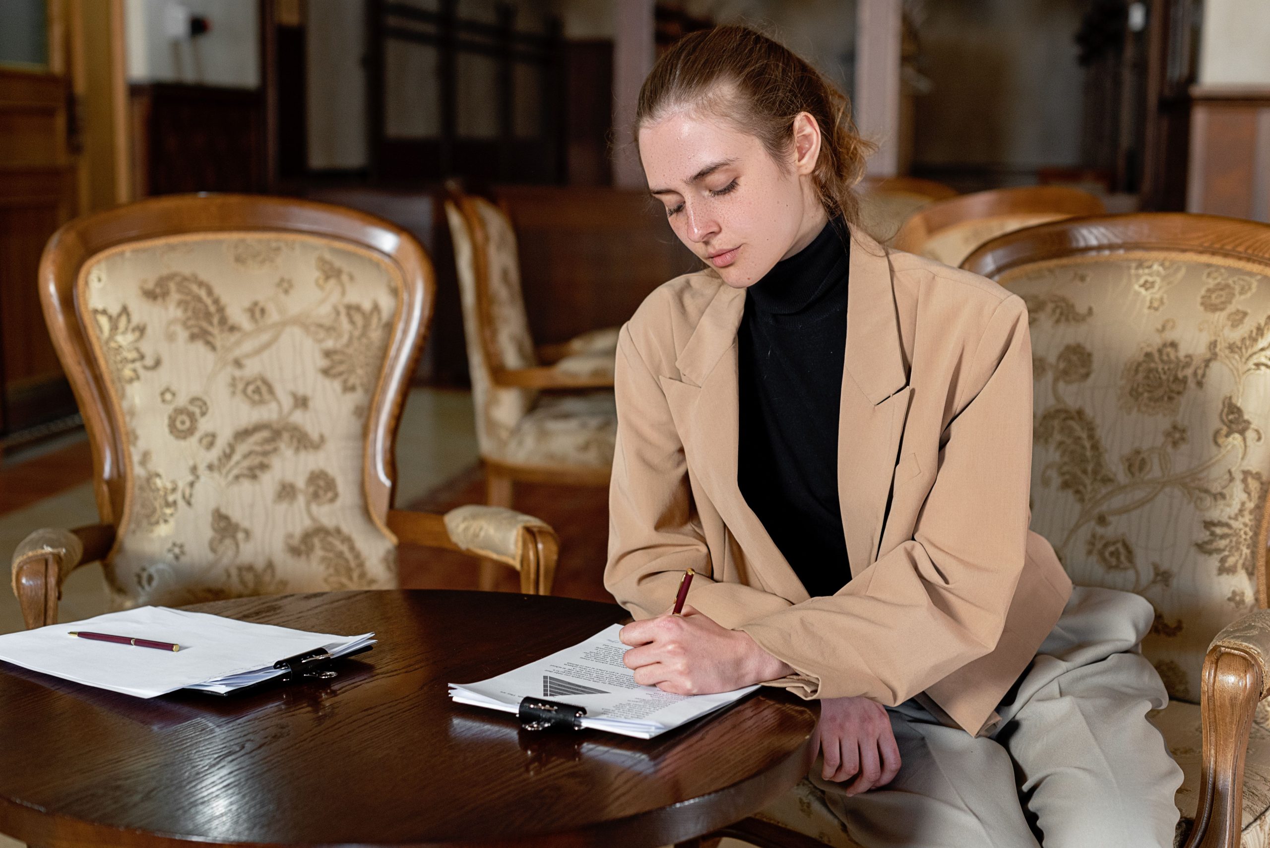 Femme signant des documents chez le notaire